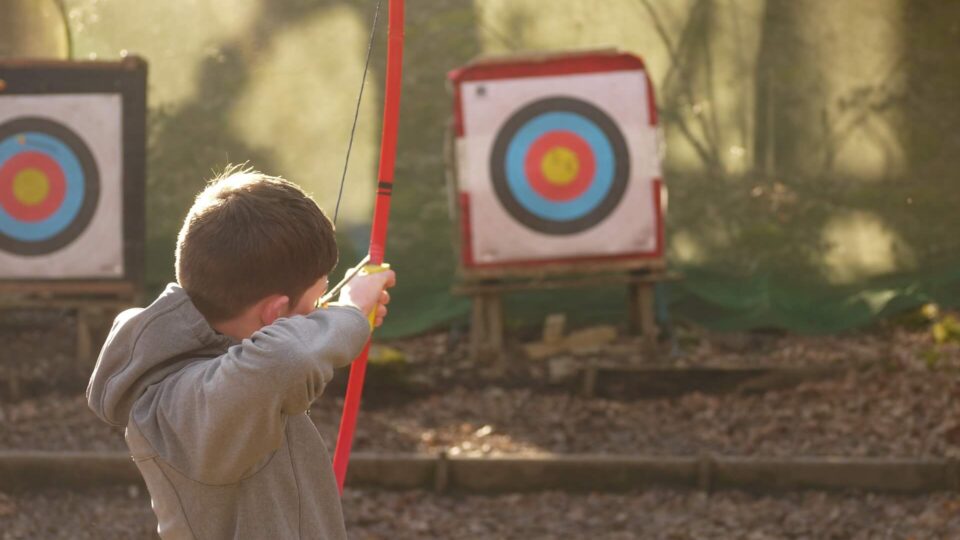 Child doing archery in Autumn at Lakeside